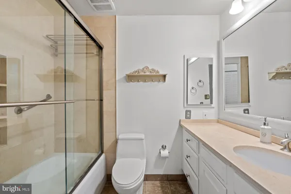 a bathroom with a sink a toilet a mirror and shower