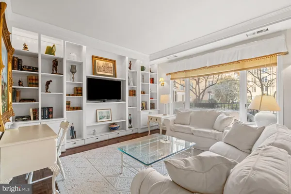 a living room with furniture a flat screen tv and a floor to ceiling window