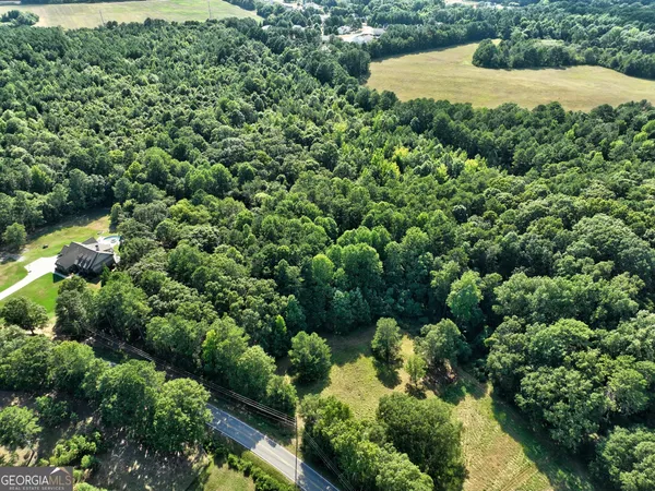 an aerial view of a residential houses with yard and swimming pool