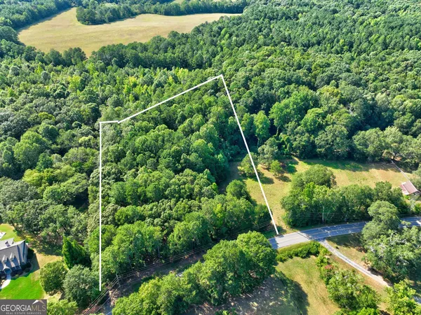 an aerial view of residential houses with outdoor space and trees