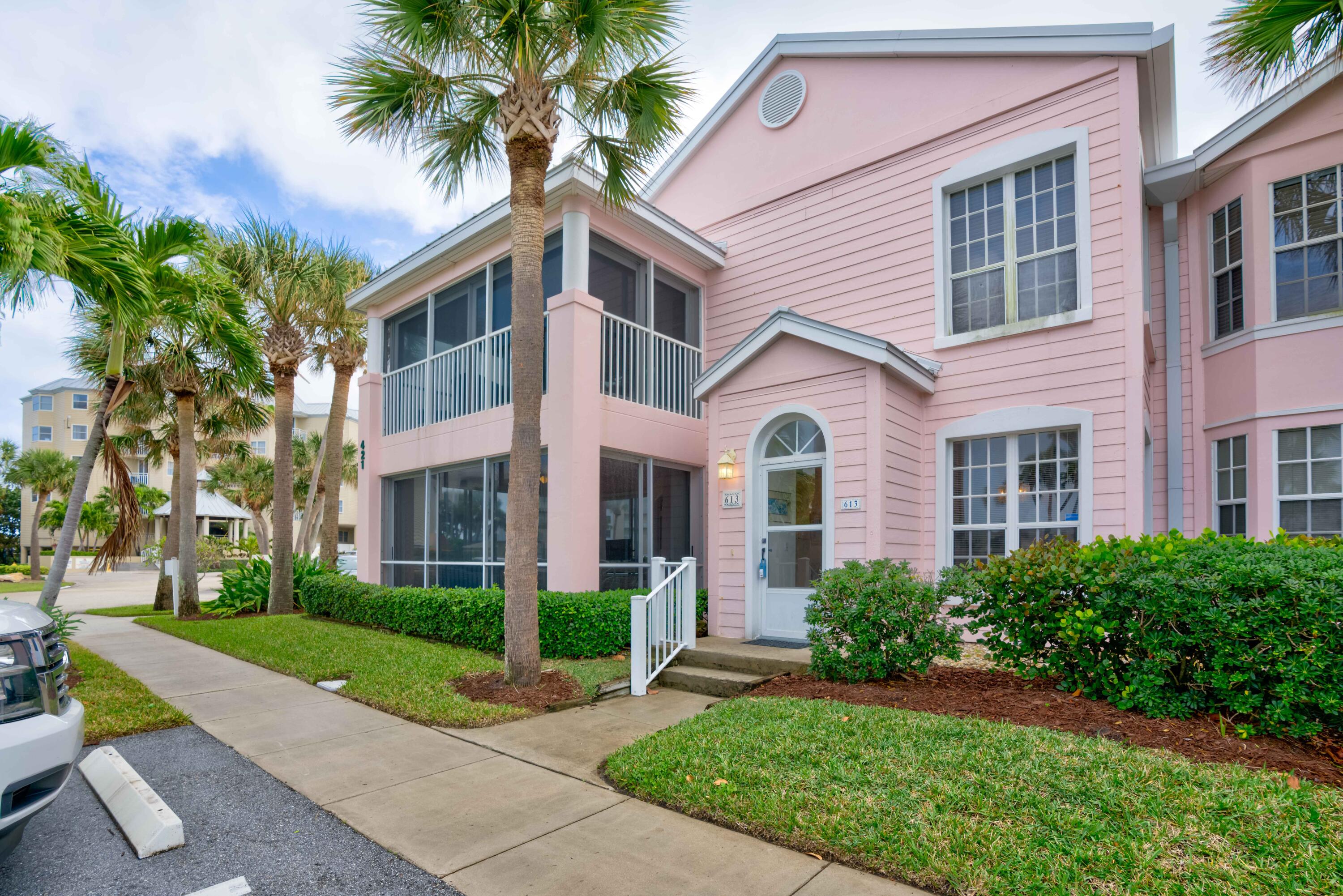 a front view of a house with a yard and potted plants