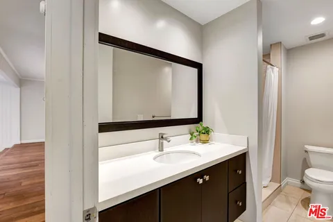 a bathroom with a sink a toilet and mirror