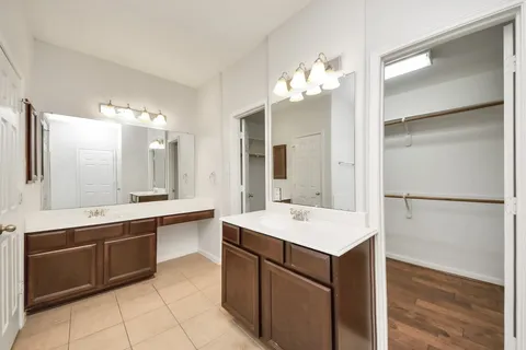 a large white kitchen with a sink and refrigerator
