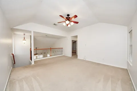 a view of a bedroom with a ceiling fan and a chandelier fan