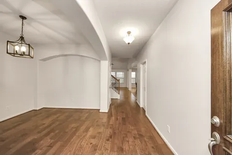 a view of a hallway with wooden floor