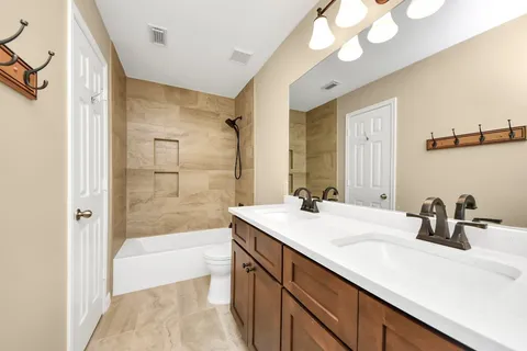 a bathroom with a sink a large mirror and a bathtub