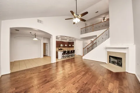 a view of a livingroom with wooden floor and a ceiling fan