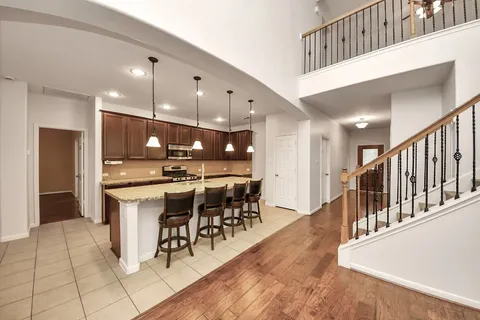 a open kitchen with stainless steel appliances kitchen island granite countertop a table chairs and a view of living room