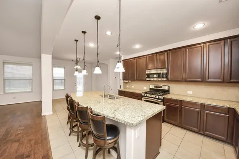 a kitchen with a stove a sink a dining table and chairs