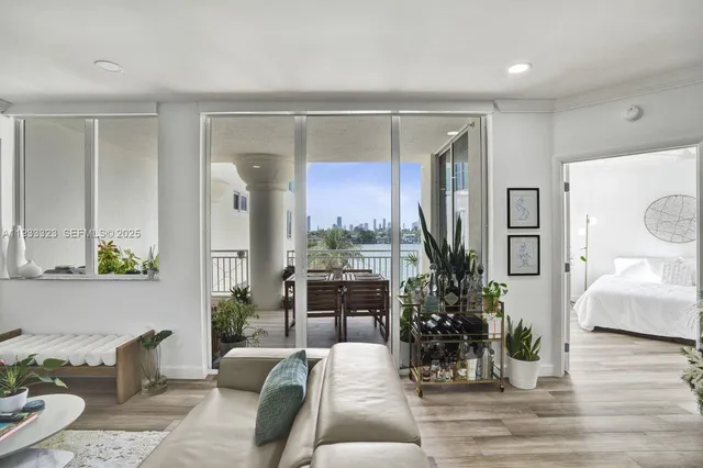 a living room with furniture large window and potted plants