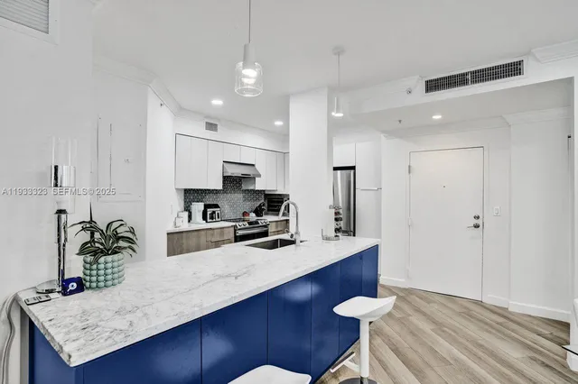 a kitchen with stainless steel appliances granite countertop a refrigerator stove and sink