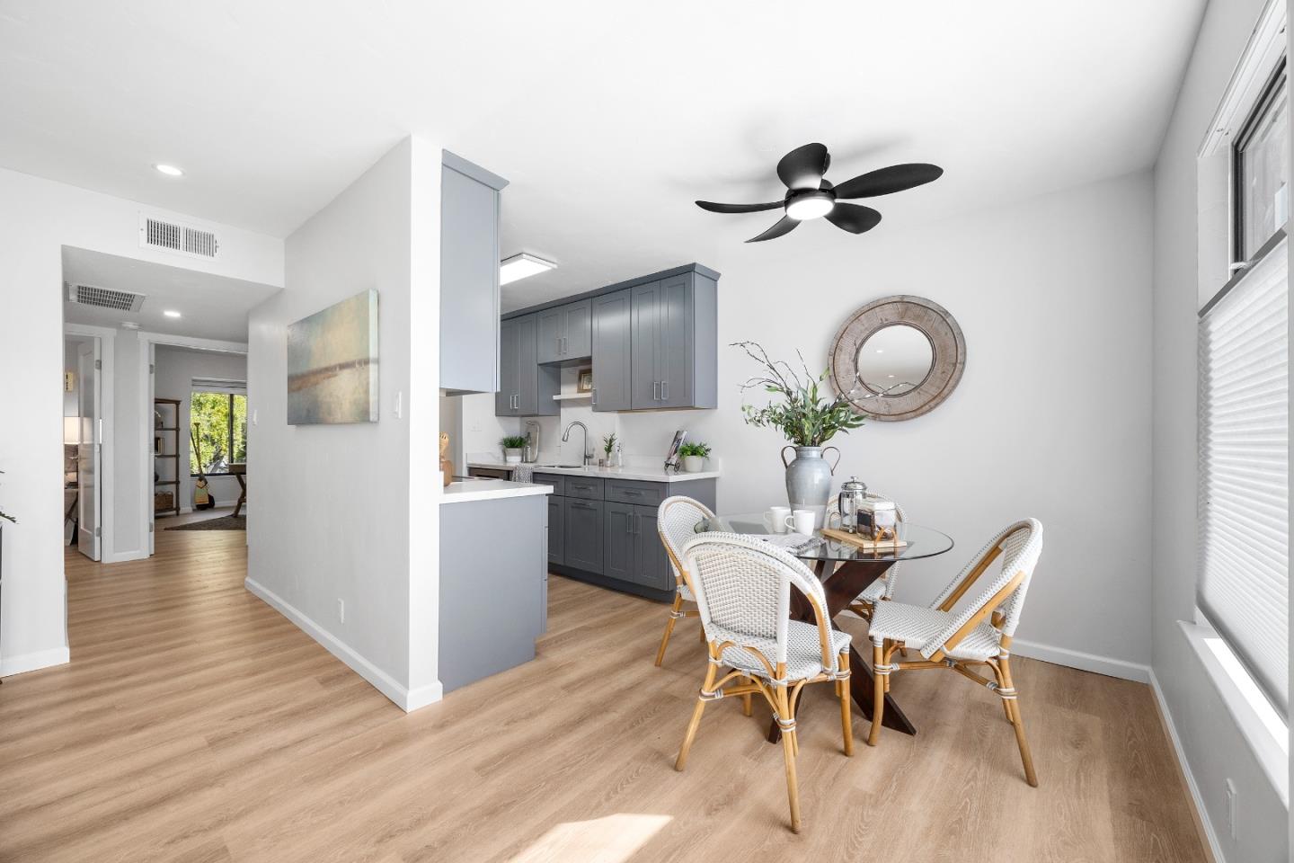 1925 46th Avenue, Unit 148 Capitola, CA 95010 - Photo 8 of 42 a dining room with wooden floor a glass table and chairs