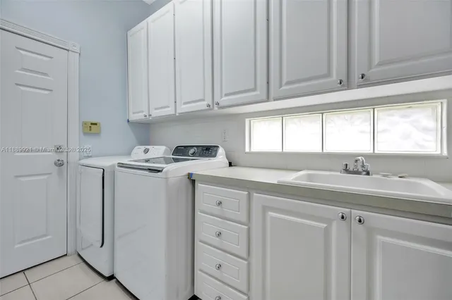 a kitchen with cabinets appliances a sink and a window