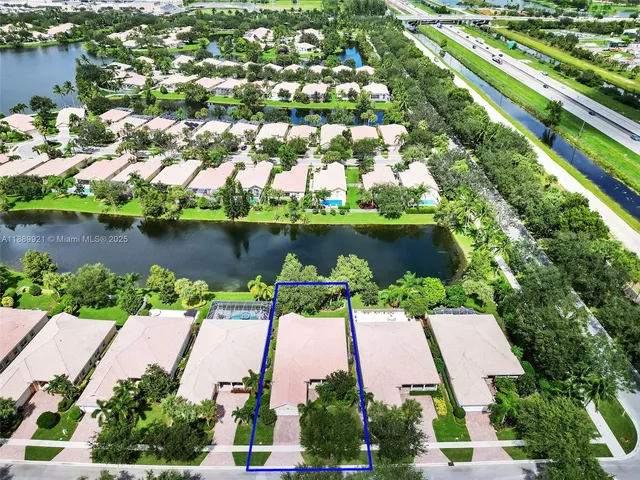 an aerial view of a house with a yard and lake view
