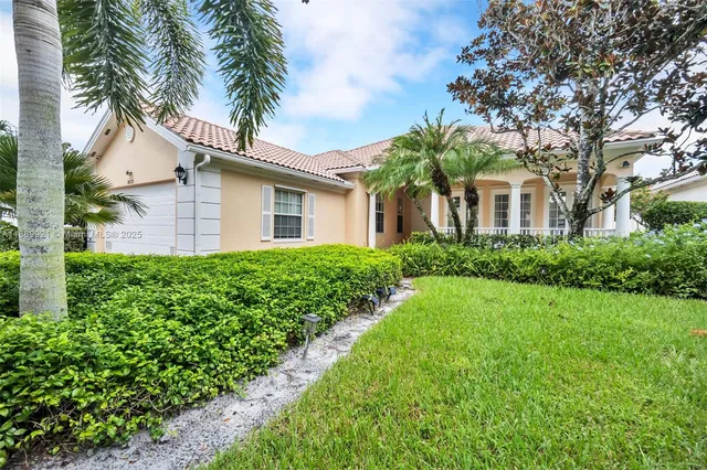a front view of a house with a garden