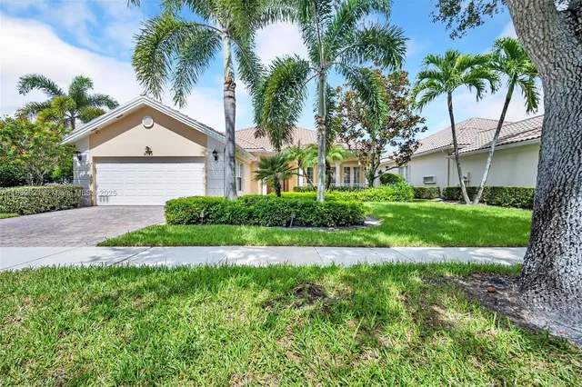 a front view of a house with a yard and potted plants