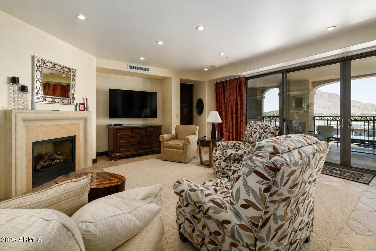 7181 East Camelback Road, Unit 1001 Scottsdale, AZ 85251 - Photo 8 of 34 a living room with furniture a fireplace and a flat screen tv