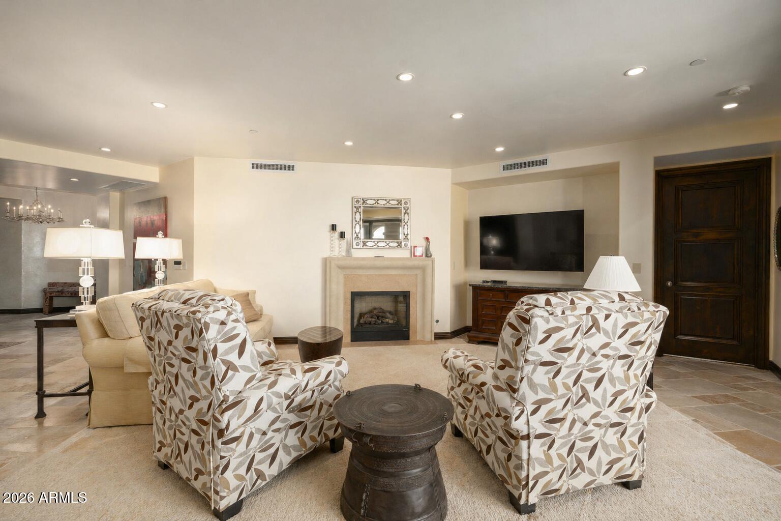 7181 East Camelback Road, Unit 1001 Scottsdale, AZ 85251 - Photo 10 of 34 a living room with furniture a flat screen tv and a fireplace