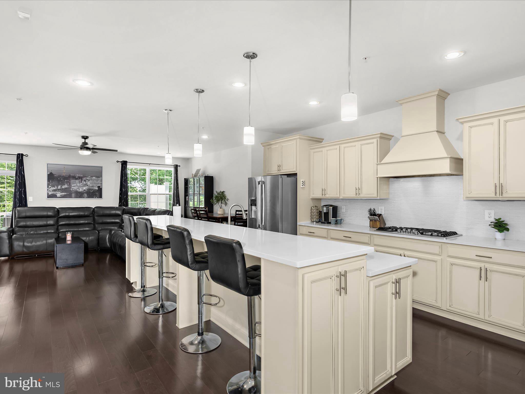 1239 Orchid Road Gambrills, MD 21054 - Photo 8 of 58 a kitchen with a sink a stove and chairs with wooden floor
