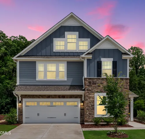 a front view of a house with yard garage and garage