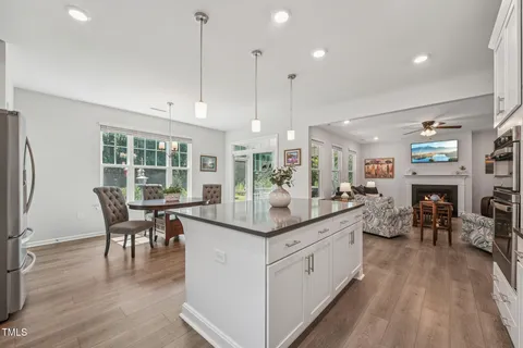 a open kitchen with stainless steel appliances granite countertop a stove and a wooden floors