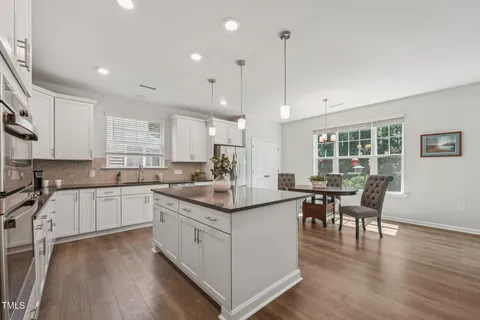 a kitchen with center island cabinets and wooden floor