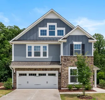 a view of a house with a yard and large tree