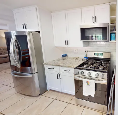 a kitchen with granite countertop a stove and a refrigerator