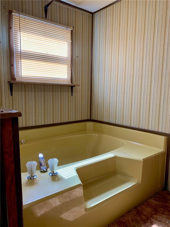 239 Crystal Spring Road Sandy Lake, PA 16145 - Photo 24 of 40 a blue bath tub sitting in a bathroom next to a window