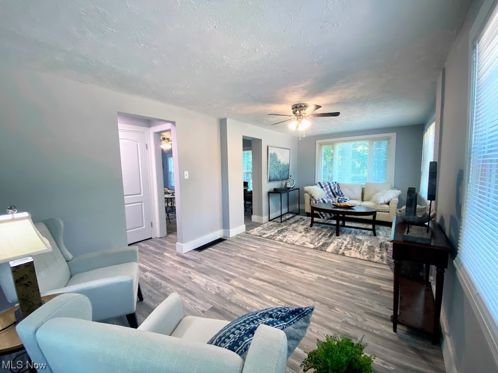 2140 Reyburn Road Cleveland, OH 44112 - Photo 7 of 18 Living room with light hardwood / wood-style floors, a textured ceiling, and ceiling fan