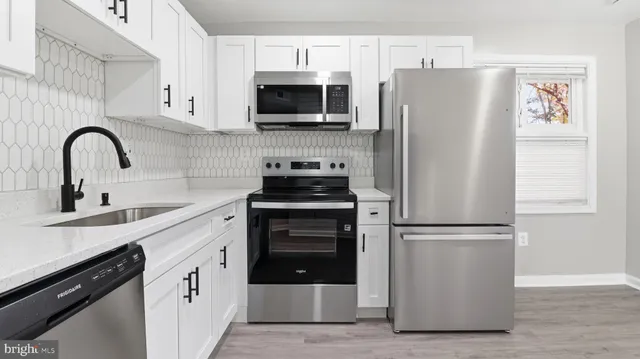 a kitchen with stainless steel appliances a refrigerator sink and cabinets