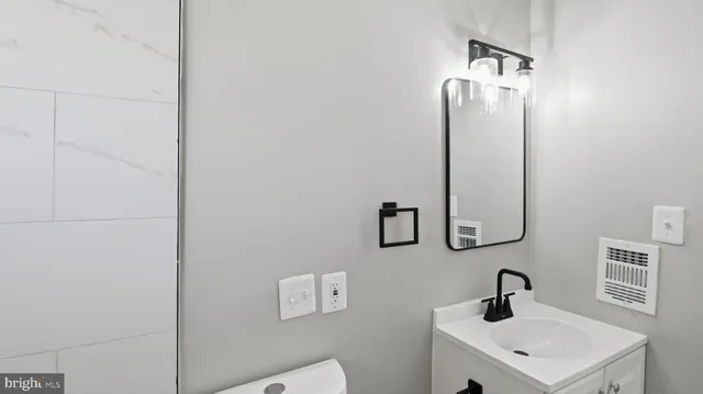 a bathroom with a toilet a sink and mirror
