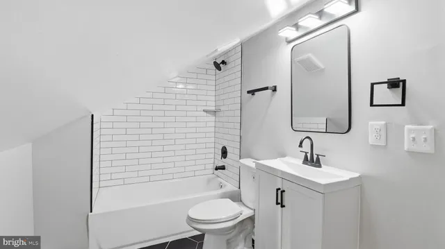 a bathroom with a toilet a sink a mirror and shower