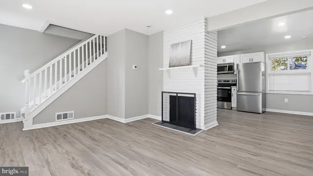 a view of a livingroom with wooden floor and staircase