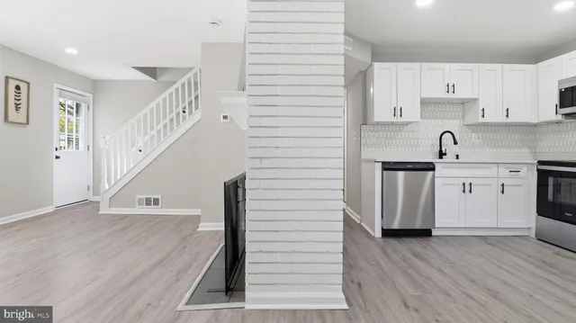 a view of kitchen with wooden floor and electronic appliances