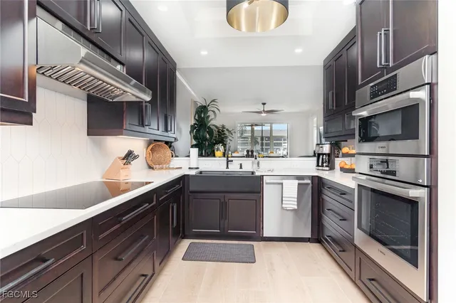 a kitchen with stainless steel appliances granite countertop a sink a stove and cabinets