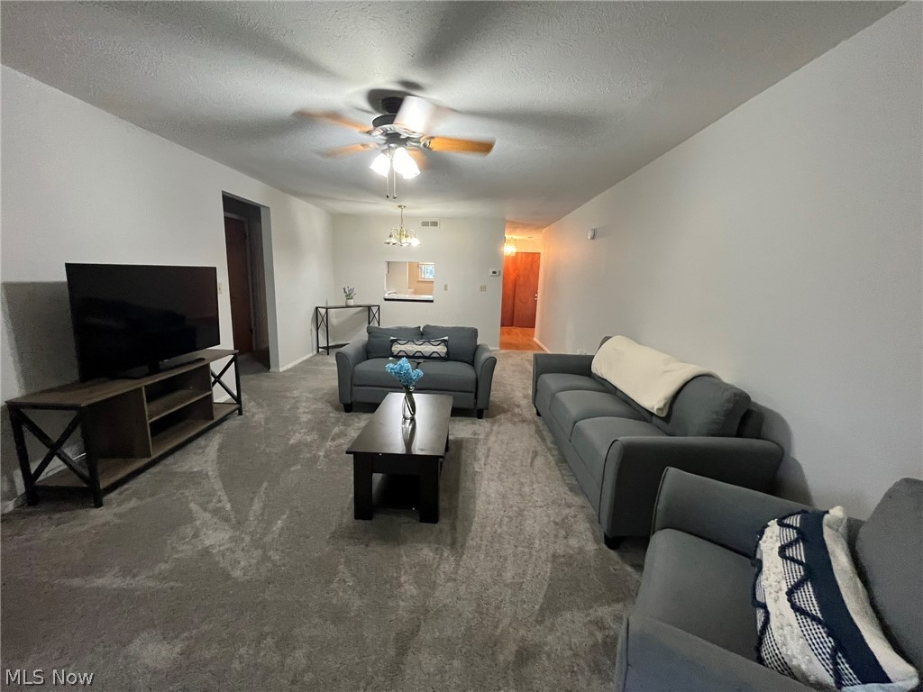 8945 West Ridge Road Elyria, OH 44035 - Photo 18 of 22 Carpeted living room featuring a textured ceiling and ceiling fan