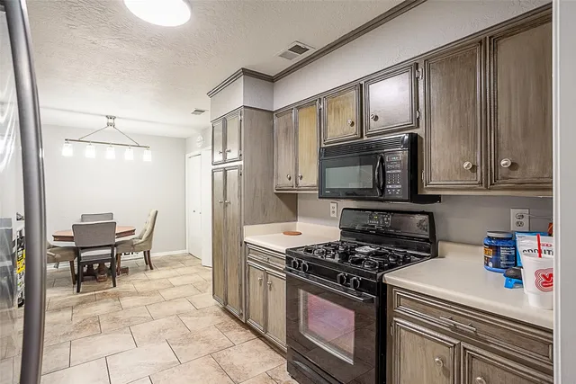 a kitchen with stainless steel appliances a stove a sink and a refrigerator