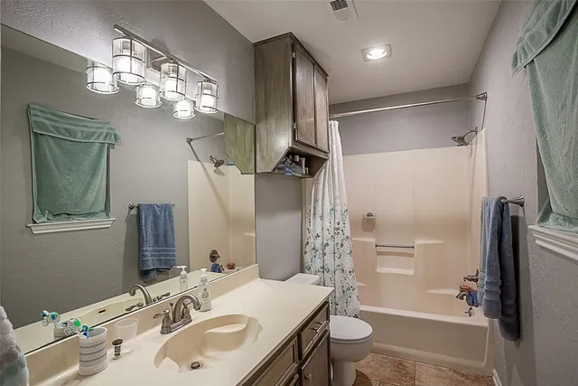 a bathroom with a sink a toilet a mirror and shower