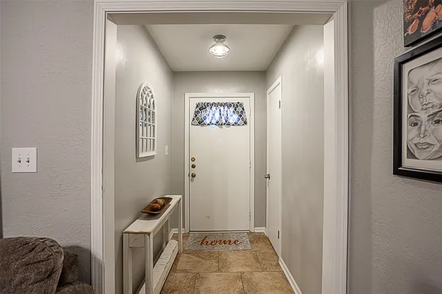a view of hallway with furniture and a chandelier
