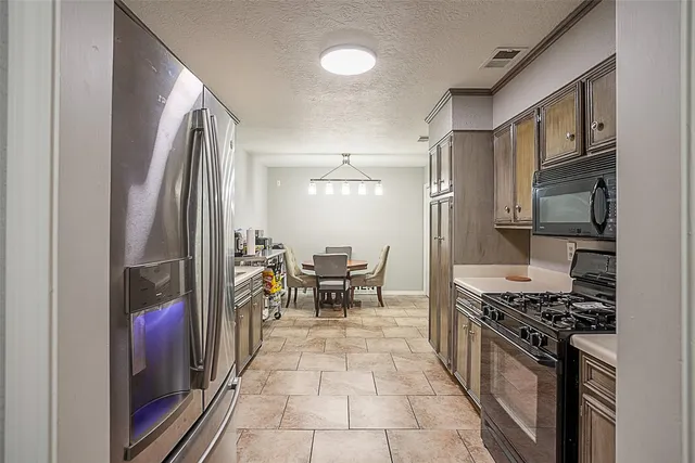 a kitchen with stainless steel appliances granite countertop a stove top oven a sink and cabinets