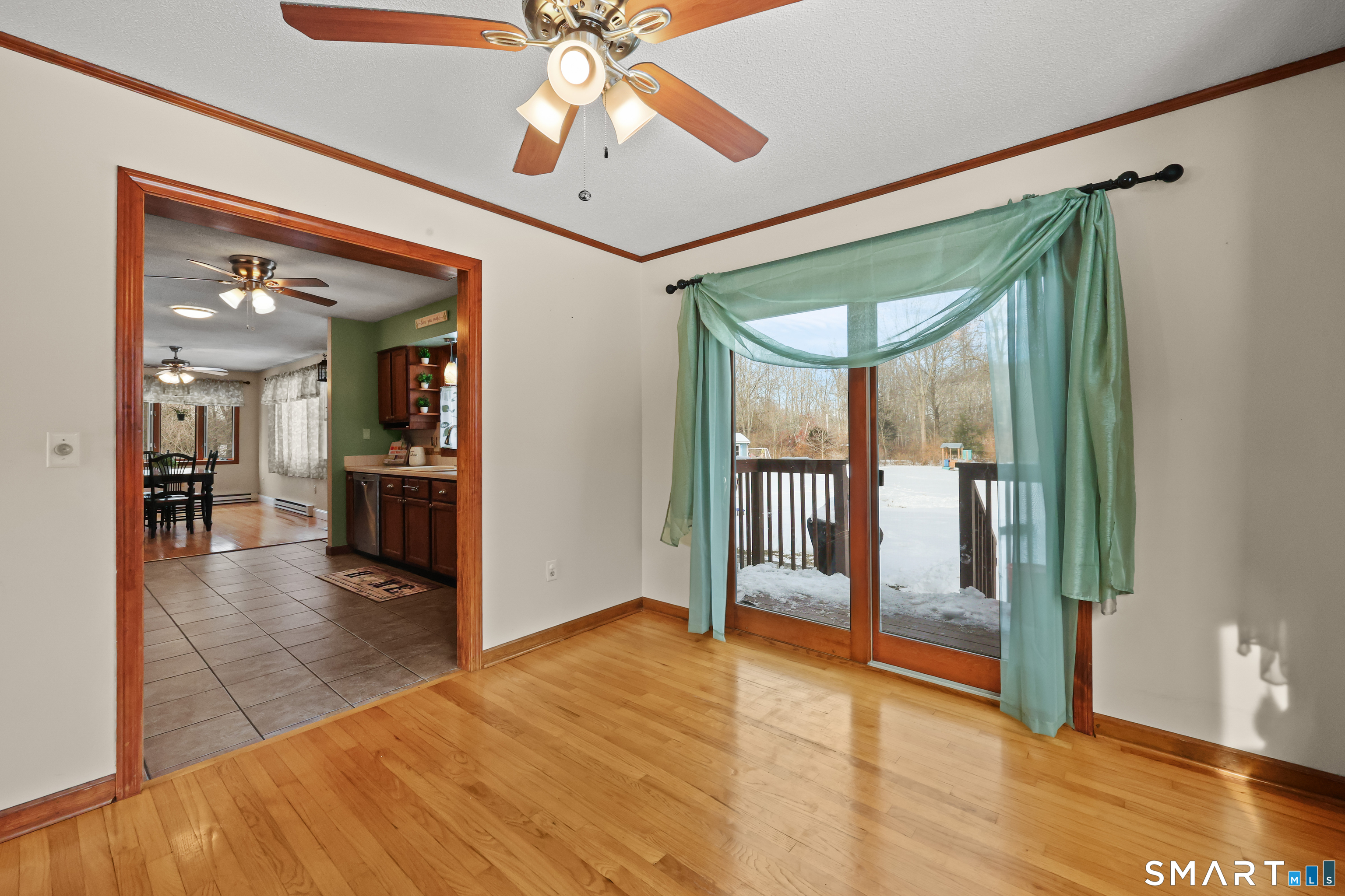 13 Basket Shop Road Hebron, CT 06248 - Photo 2 of 38 a view of a hallway with wooden floor and a dining room with chandelier