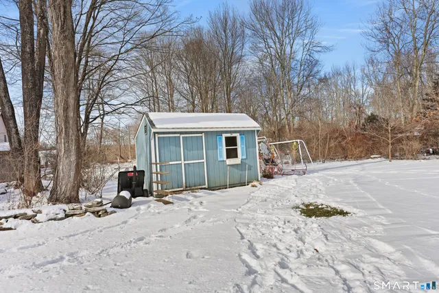 a front view of a house with a yard covered in snow