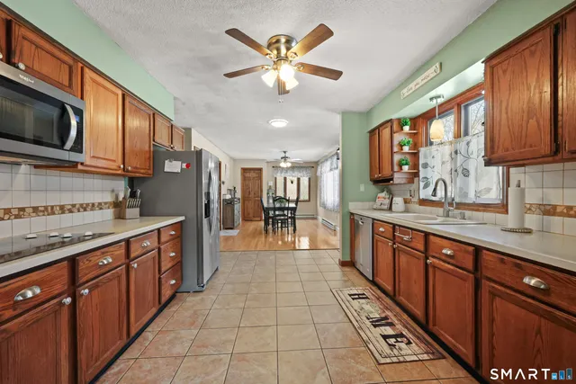 a large kitchen with stainless steel appliances granite countertop a sink and cabinets