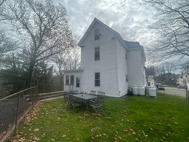 a backyard of a house with table and chairs
