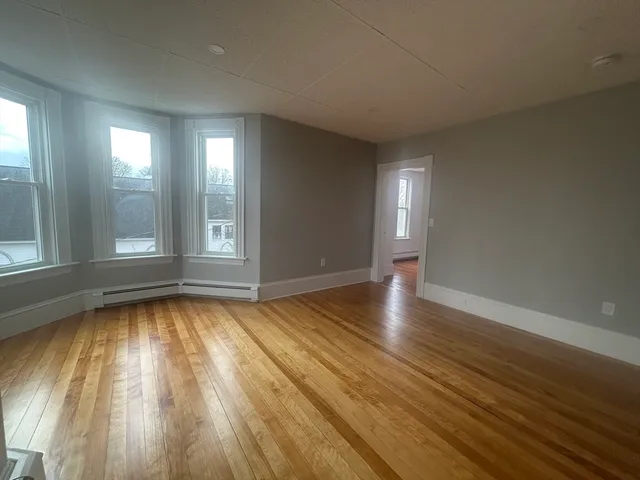 wooden floor in an empty room with a window