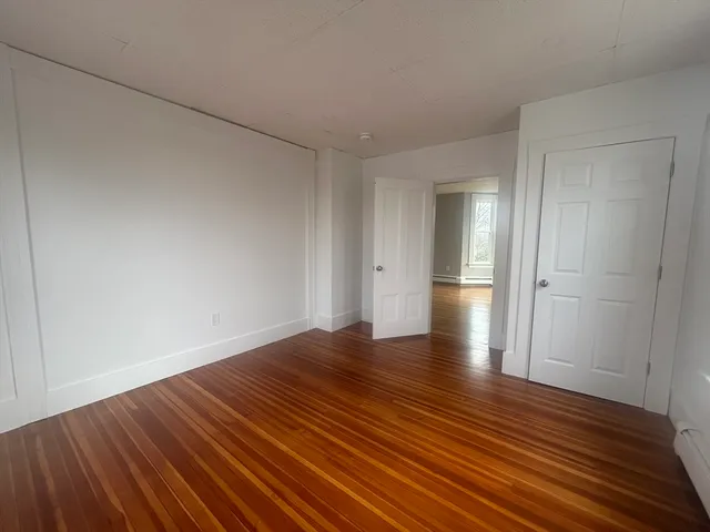 a view of an empty room and wooden floor