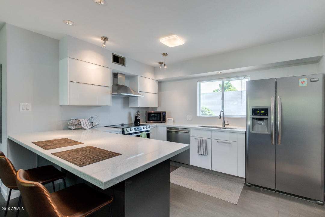 1250 East Bethany Home Road, Unit 24 Phoenix, AZ 85014 - Photo 1 of 19 a kitchen with a stove a refrigerator and a sink