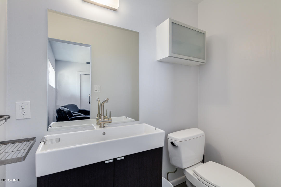 1250 East Bethany Home Road, Unit 24 Phoenix, AZ 85014 - Photo 11 of 19 a bathroom with a sink a toilet and mirror