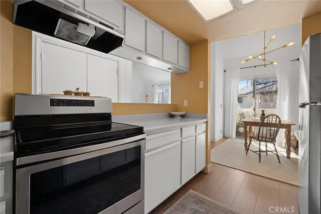 a kitchen with stainless steel appliances white cabinets and a refrigerator